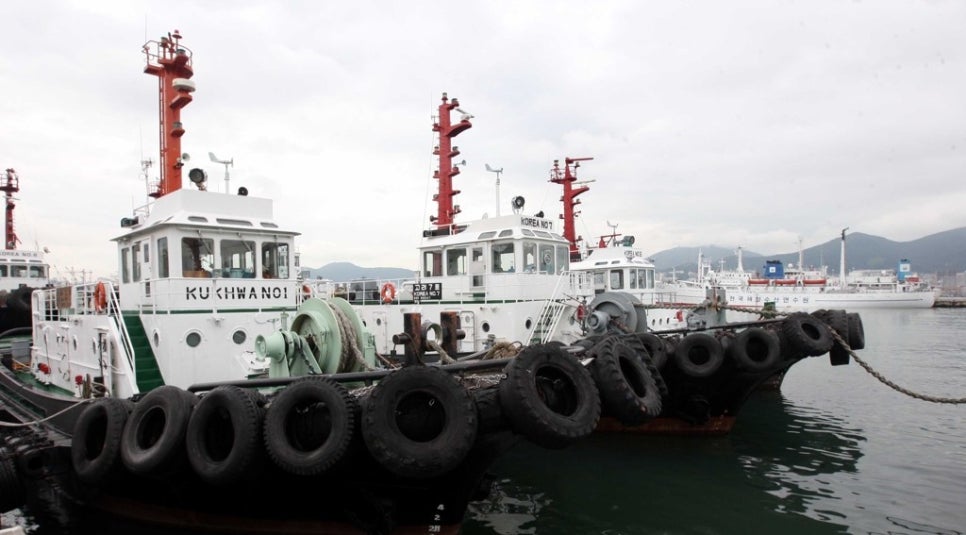 Several tugboats alongside each other at a harbor